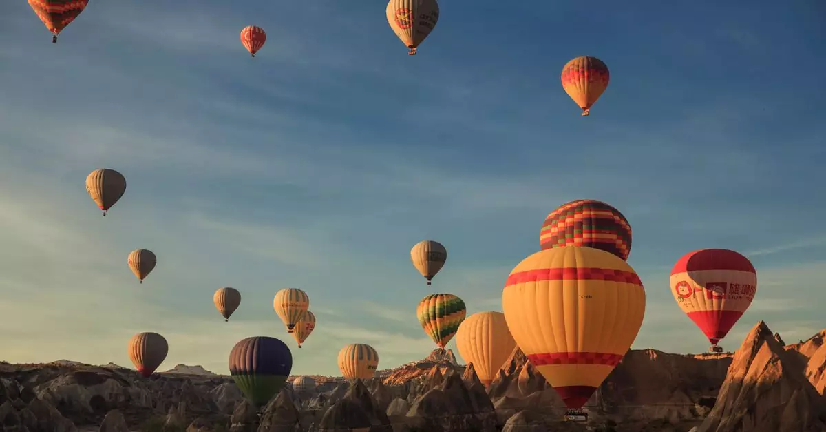 Colorful hot air balloons soaring over Cappadocia's unique landscape at sunrise.
