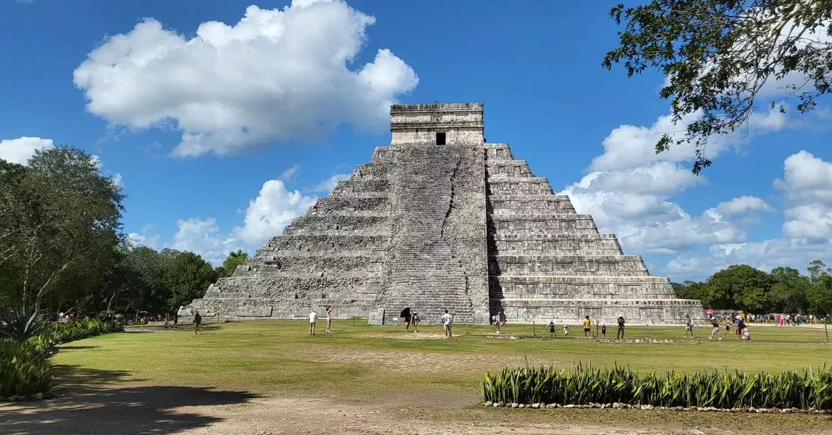 Historic El Castillo pyramid under blue skies in Chichén Itzá, a famous Mayan landmark in Mexico.