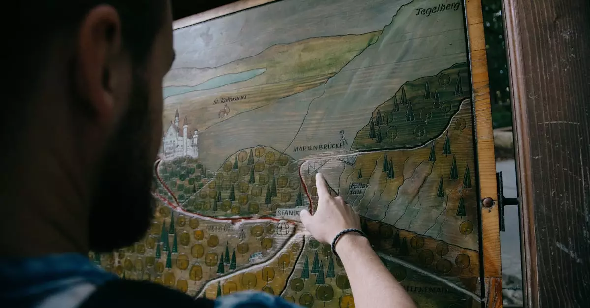 Back view of anonymous man pointing on wooden board with carved painting of mountains and roads