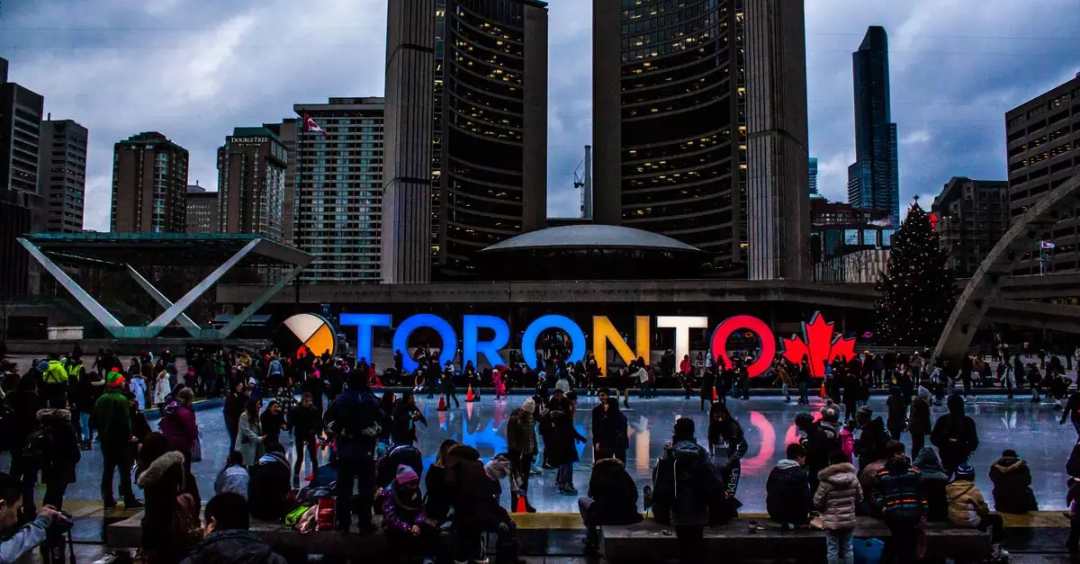 Vibrant evening at Toronto City Hall with festive crowd enjoying the cityscape.