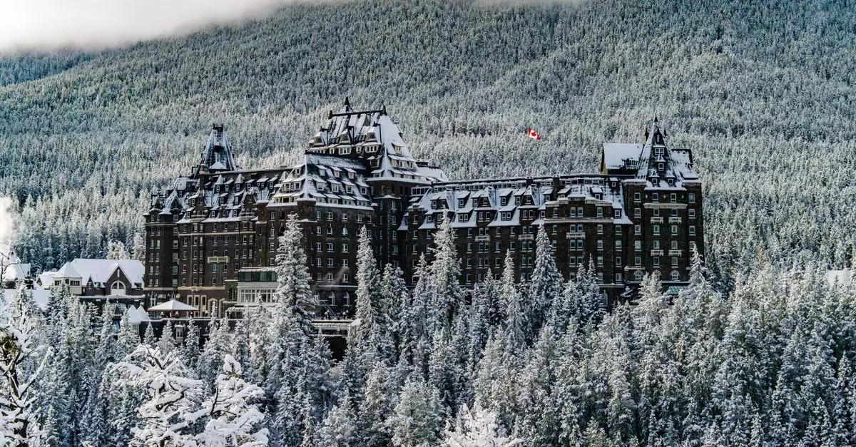 Stunning winter view of Banff Springs Hotel surrounded by snowy forests and mountains in Canada.