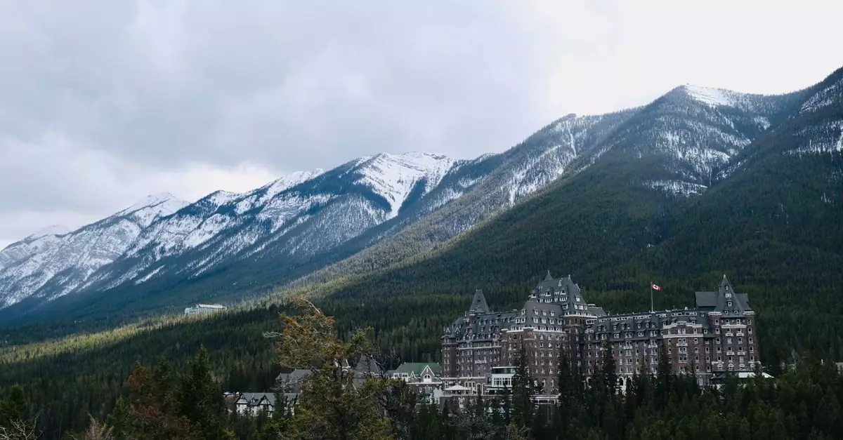 Scenic view of Banff Springs Hotel amidst snow-capped mountains and greenery.