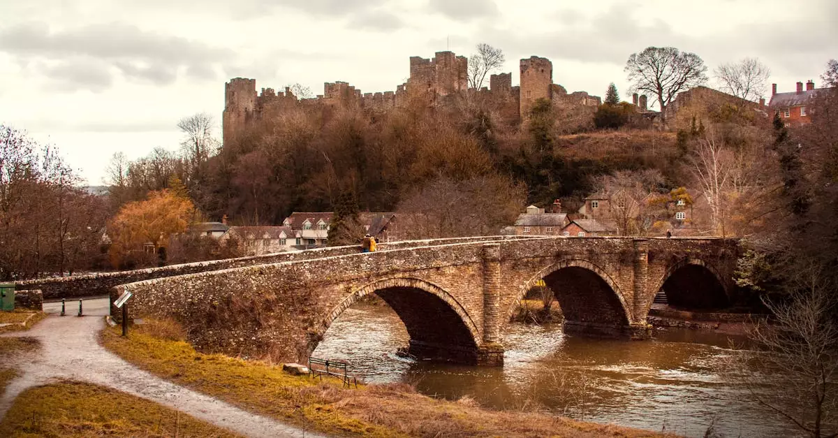 Scenic view of Ludlow Castle and historic stone bridge over the river in winter.