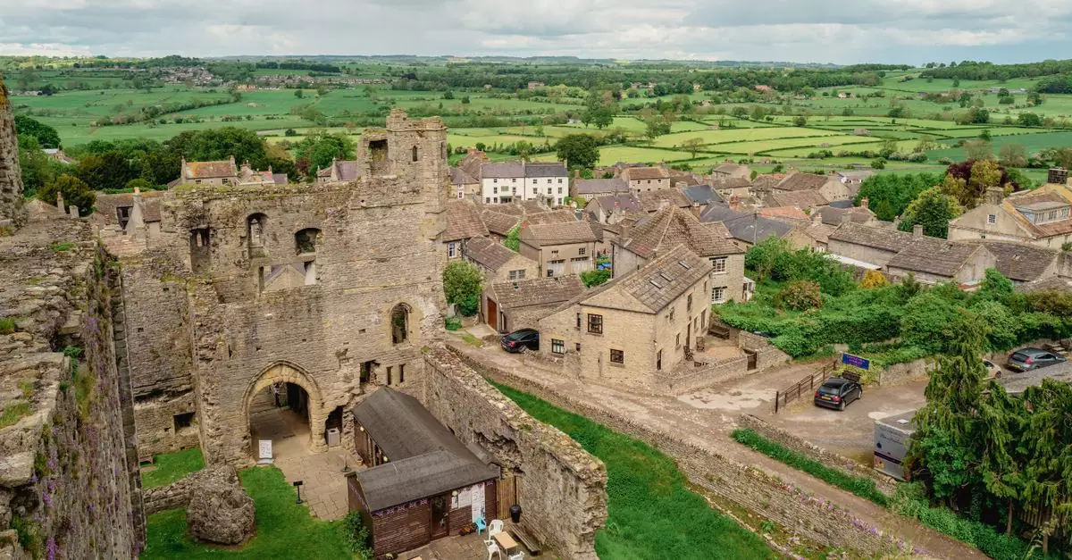A scenic view of Middleham Castle ruins and surrounding countryside in Middleham, England.