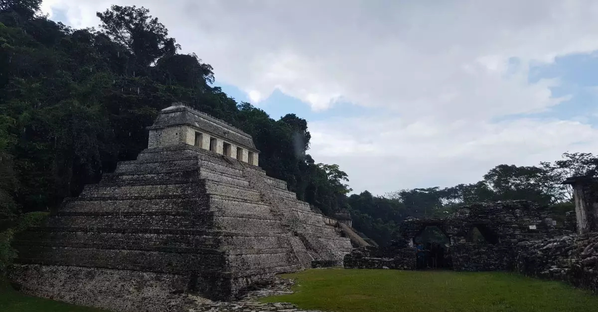 View of the historic Temple of the Inscriptions amidst lush jungle in Palenque, Chiapas.