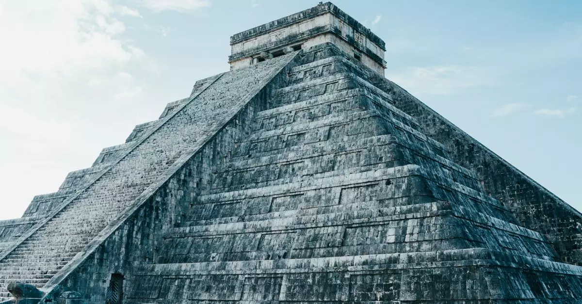 Majestic view of the ancient Mayan pyramid at Chichen Itza under a clear sky.