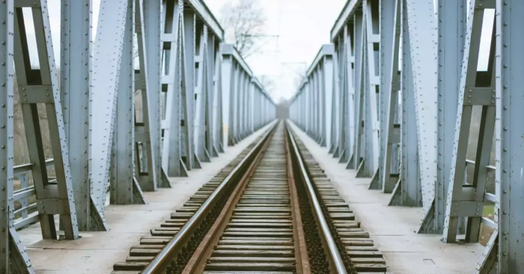 A historical railway bridge showcasing symmetrical iron structures and tracks.