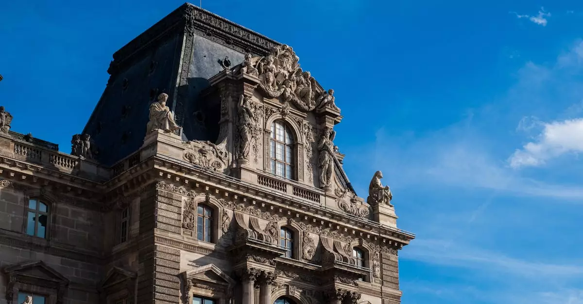 Close-up of ornate architectural features of the Louvre in Paris against a blue sky.