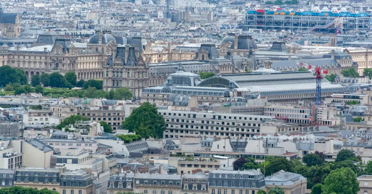Aerial view of Paris showcasing the Louvre Museum and iconic cityscape in a summer setting.