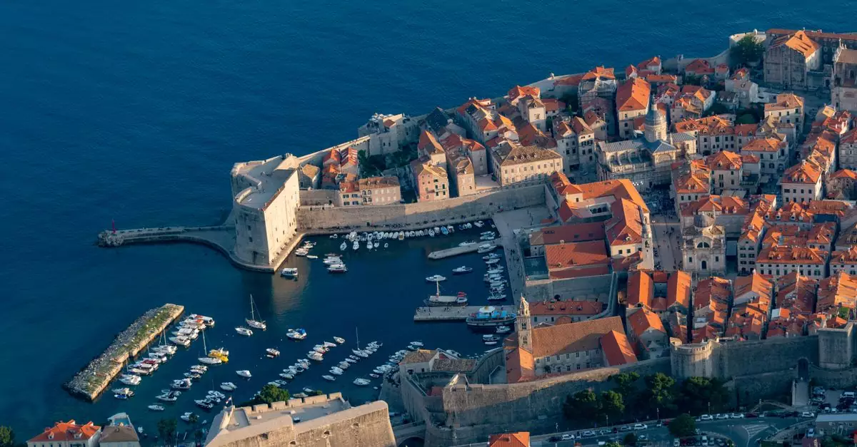 Stunning aerial shot of Dubrovnik's old town and harbor, showcasing its iconic medieval walls and Adriatic Sea views.