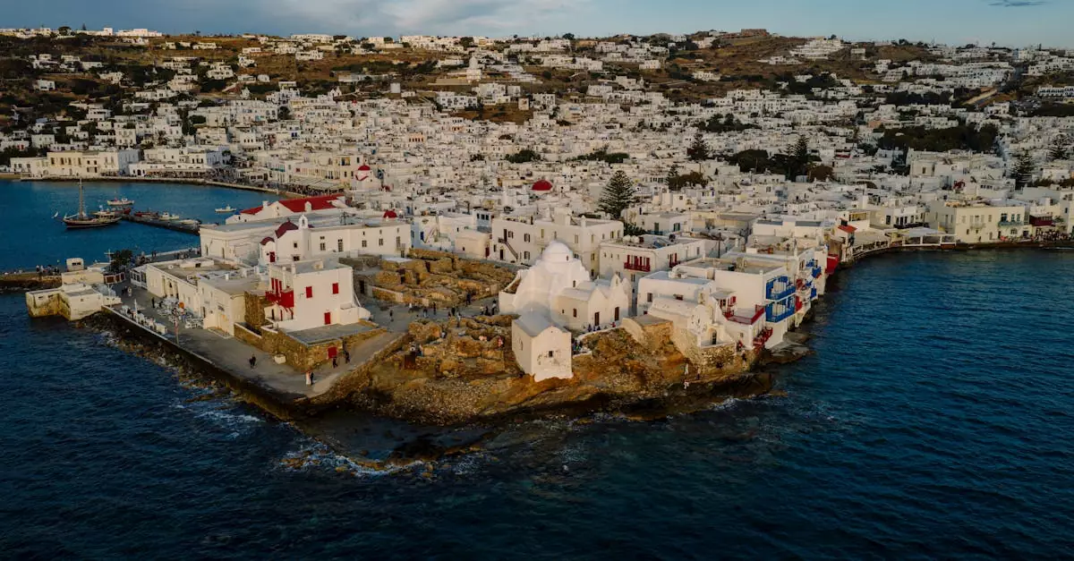 Stunning aerial view of Mykonos town with whitewashed buildings and blue sea, showcasing Greek island architecture.