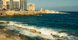 Stunning coastal view of Valletta, Malta with urban skyline and azure sea.