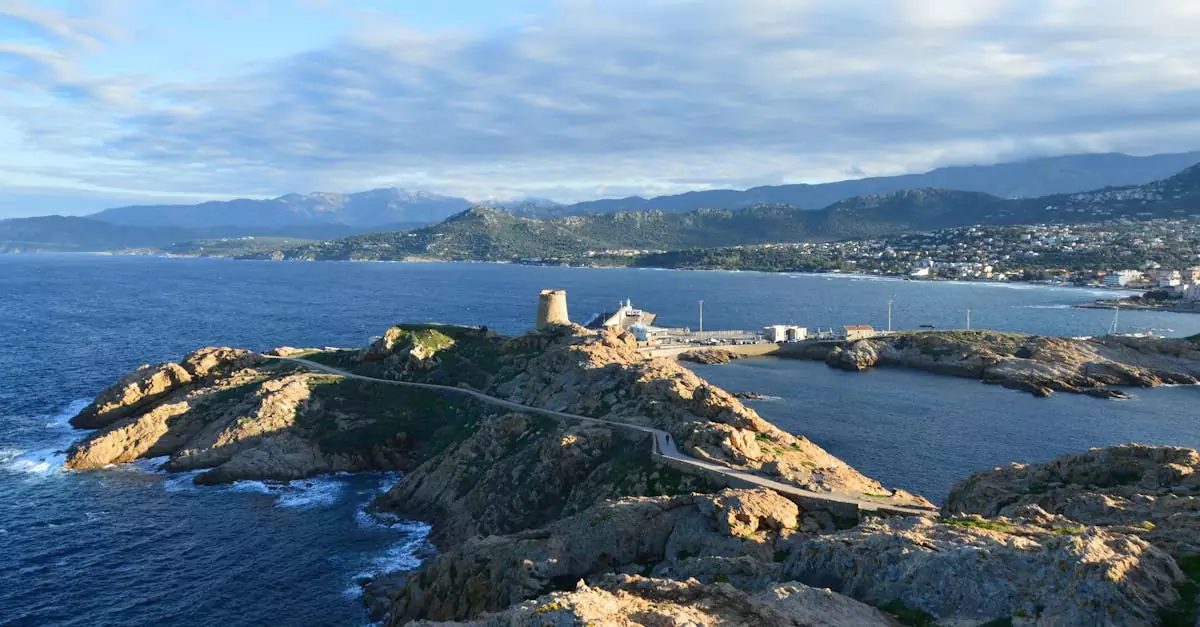 Picturesque coastal view of L'Île-Rousse, Corsica at dusk, featuring rocky landscapes and a historic watchtower.