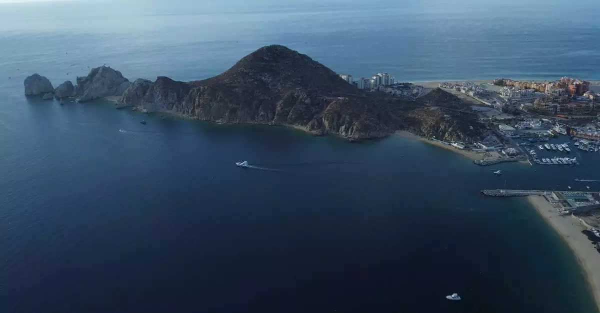 Stunning aerial view of Cabo San Lucas coast showcasing rugged terrain and vast ocean.