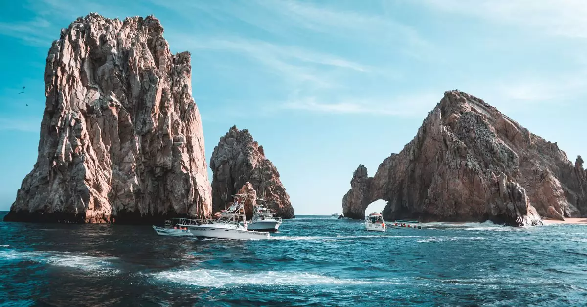 Stunning Cabo San Lucas seascape with rock formations and boats on a clear day.