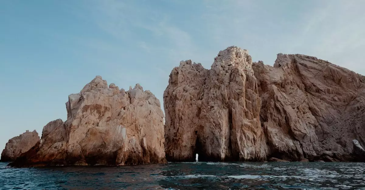 Stunning view of El Arco rock formation, Cabo San Lucas, surrounded by the sea under a blue sky.