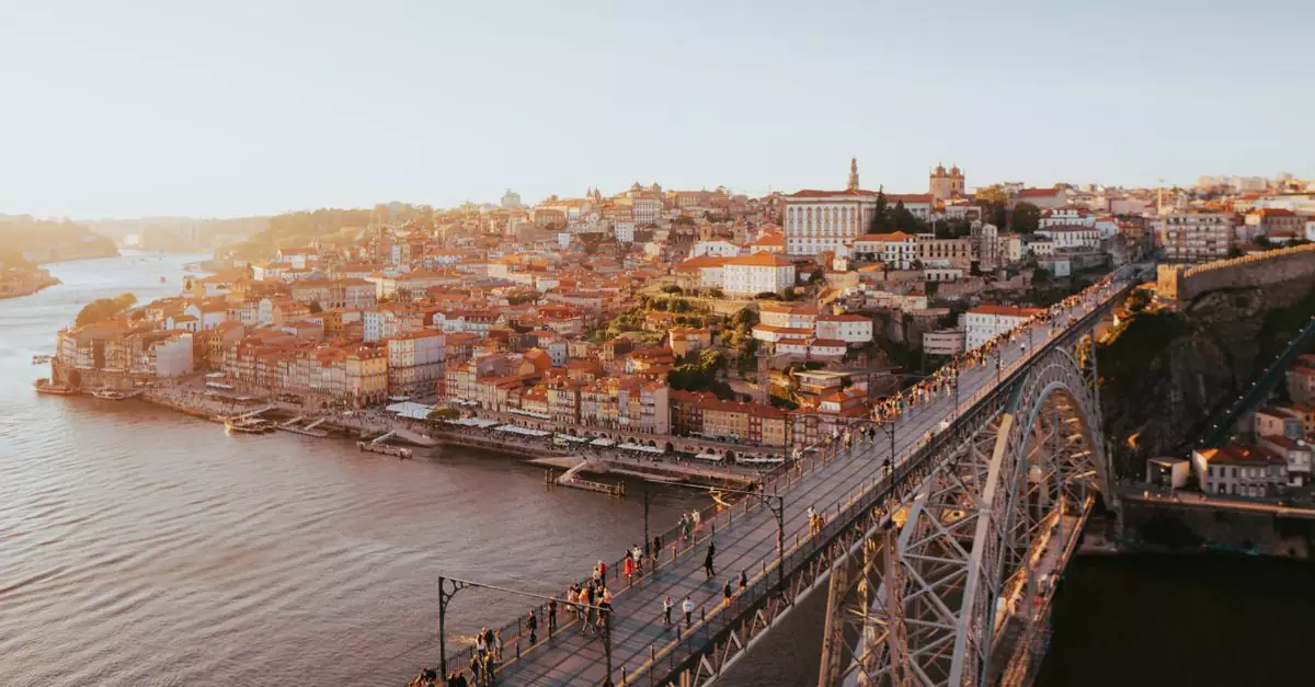 A stunning aerial view of Porto's historic cityscape and Dom Lu&iacute;s I Bridge over the Douro River at sunset.