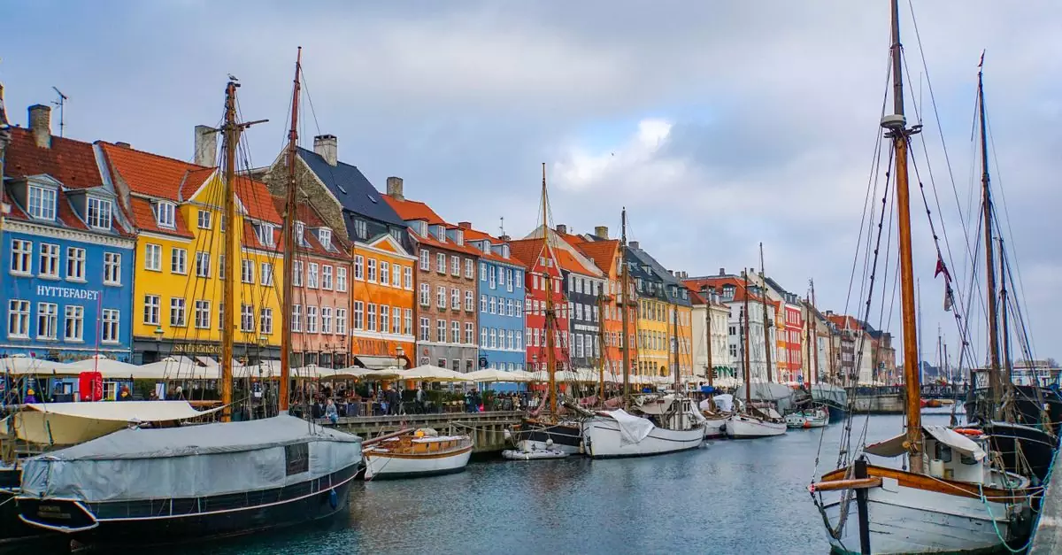 Scenic view of Nyhavn Canal with colorful buildings and moored boats in Copenhagen.