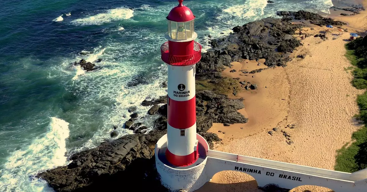 A stunning aerial shot of the Barra Lighthouse in Salvador against a rocky coastline.
