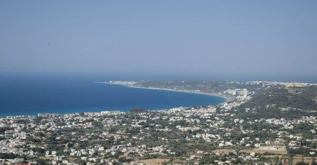 Stunning aerial view of a coastal cityscape and azure sea in Greece on a sunny day.