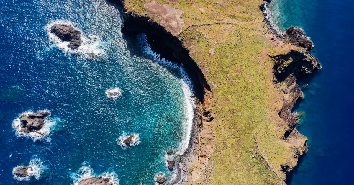 Breathtaking aerial view of Madeira's coastline with rocky formations and blue ocean.