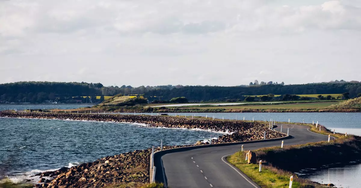 A picturesque winding road along the coast with expansive river and countryside views.