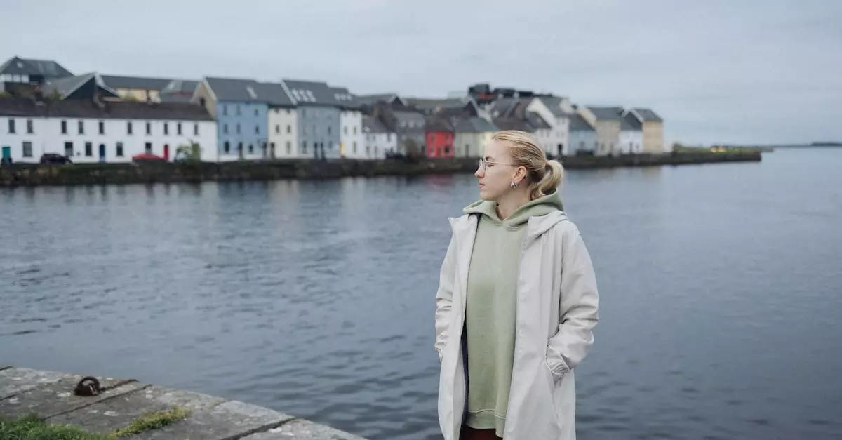 A woman standing by the waterfront in Galway, Ireland, on a cloudy day.