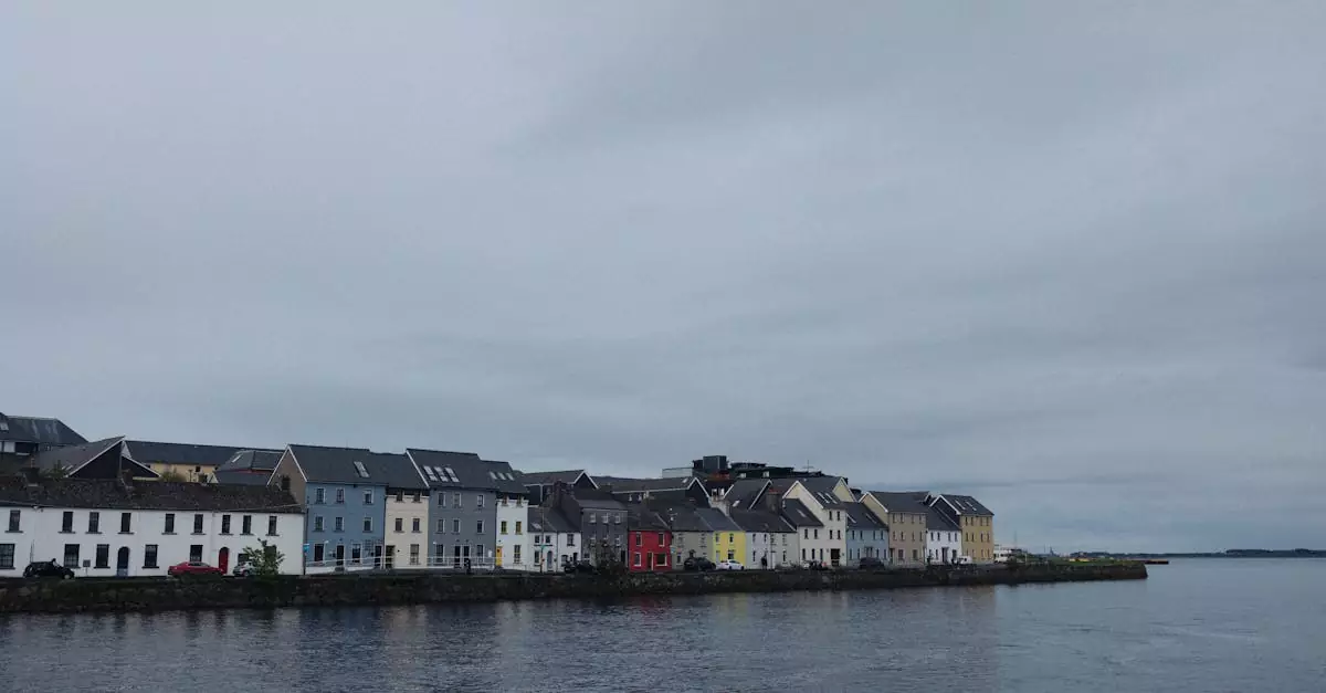 Quaint row of colorful houses along Galway's waterfront, evoking a serene Irish charm.