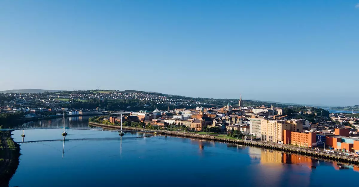 Aerial shot of Derry city and Peace Bridge over River Foyle at sunrise.