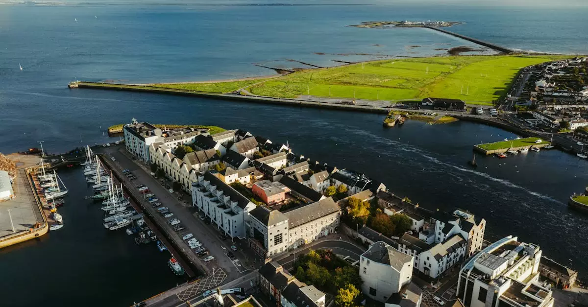 Stunning aerial shot of Galway's coastal harbor with vibrant green landscape and blue ocean waters.