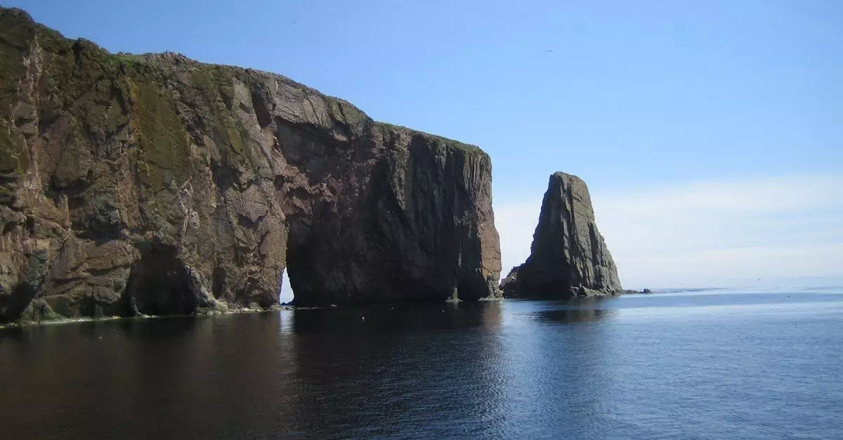 Beautiful view of Percé Rock against the clear blue sky and ocean waters in Quebec.
