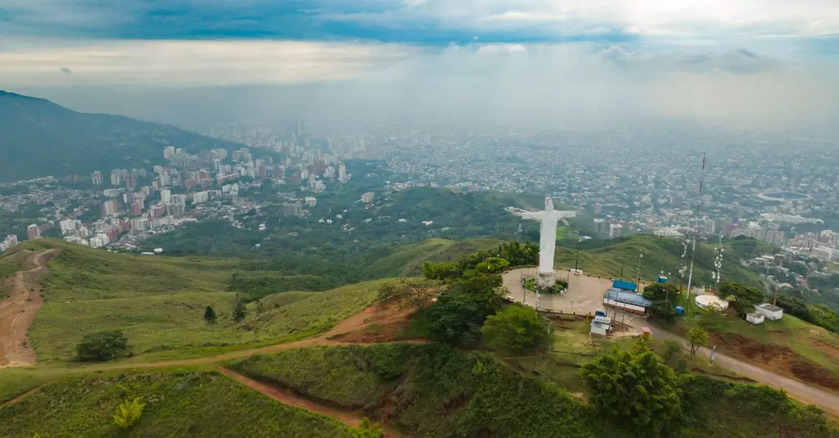 Stunning aerial view of Cristo Rey statue overlooking Cali's cityscape in Colombia.