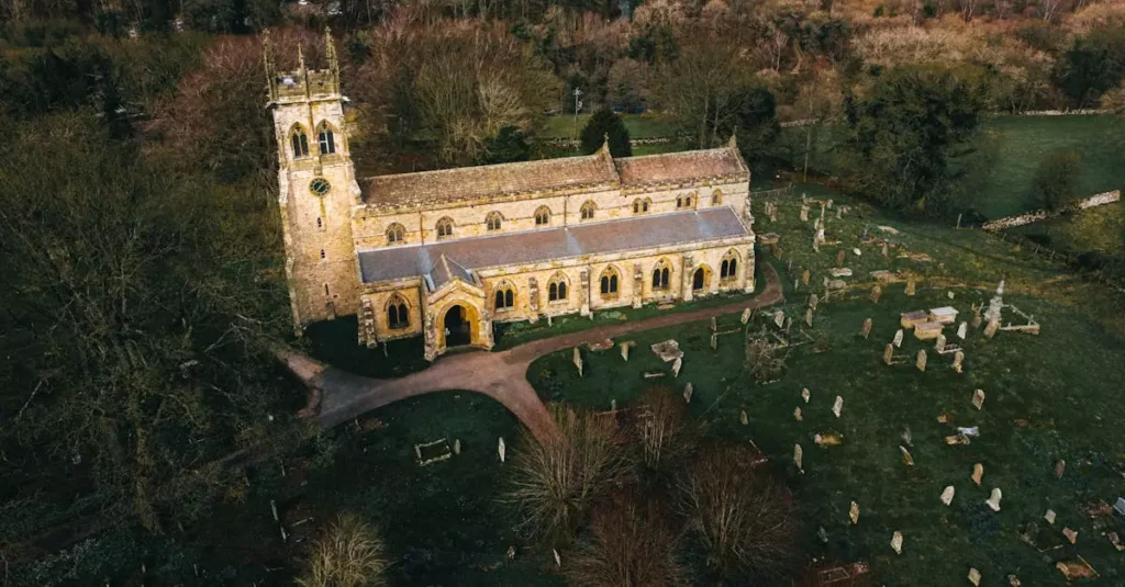 England's Best Countryside Escapes: Villages & Routes 2 Drone shot capturing the historic Aysgarth Church and graveyard in England.