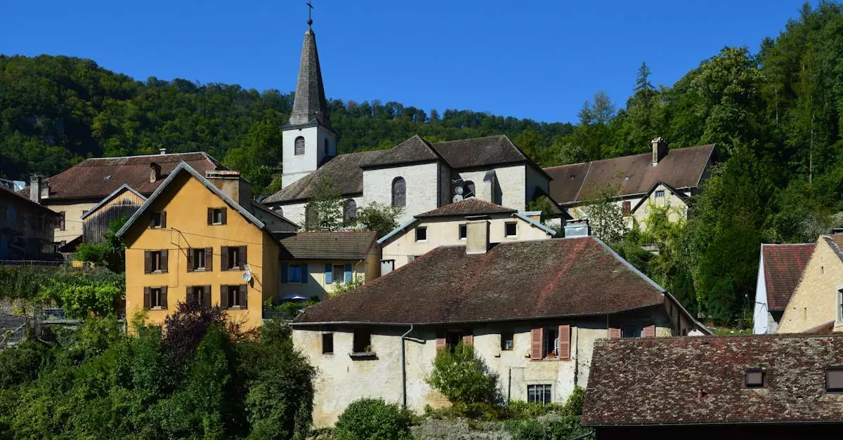 Quaint village of Lods, France with rustic buildings and a historic church under a clear blue sky.