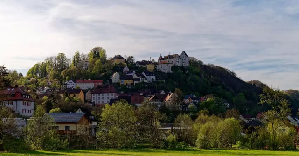 Picturesque hillside village of Egloffstein in Bavaria, Germany, surrounded by lush greenery.
