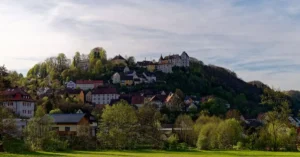 Picturesque hillside village of Egloffstein in Bavaria, Germany, surrounded by lush greenery.