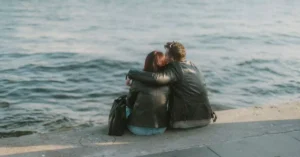 Couple seated by the Bosphorus in Istanbul, sharing a moment by the waterfront.