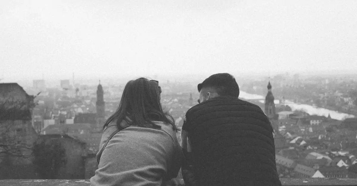 A black and white photo of a couple admiring the cityscape of Heidelberg from above.