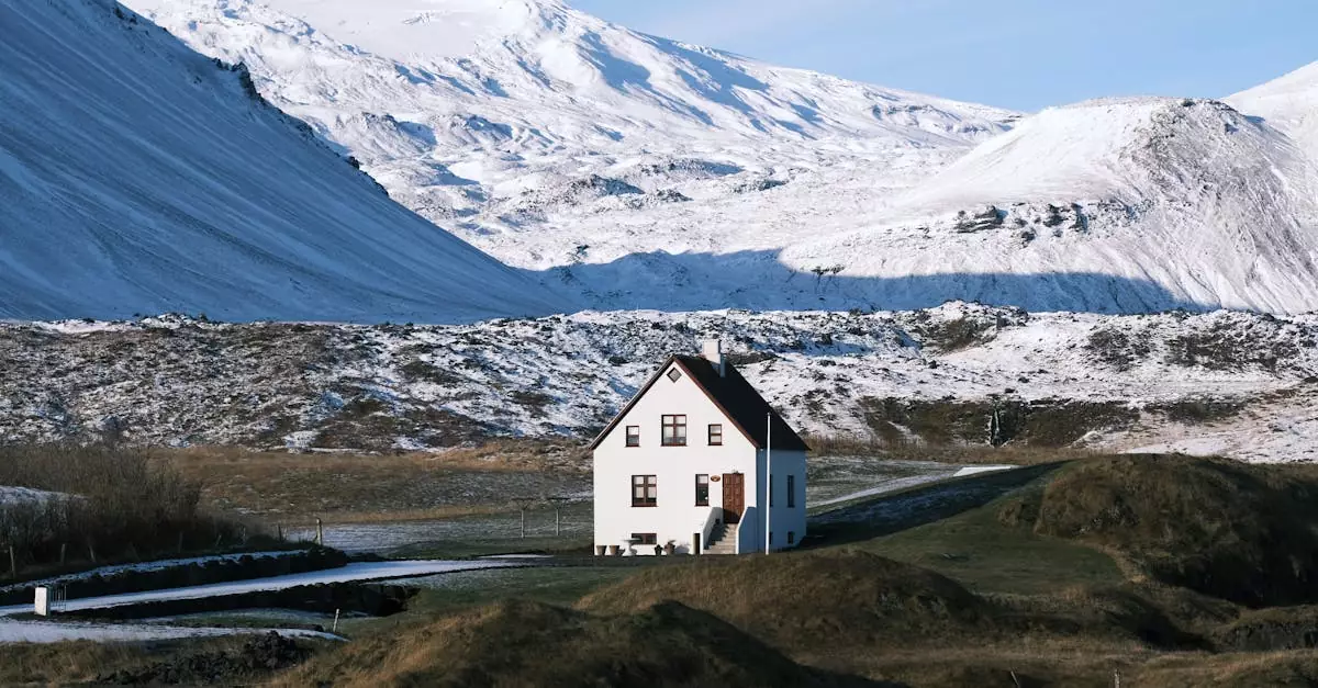 A lone white house nestled in Iceland's majestic snow-covered mountainscape.