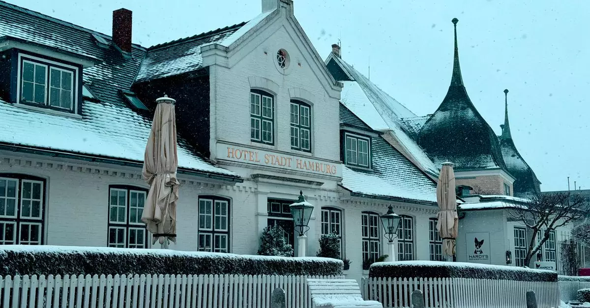 Charming snowy facade of Hotel Stadt Hamburg in winter's serene atmosphere.