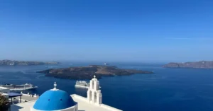 Breathtaking view of Santorini with blue domes and Aegean Sea in the background. Iconic Greek island architecture.