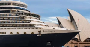 Queen Elizabeth cruise ship docked near Sydney Opera House, Australia at daytime.