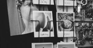 A black and white photo showcasing a display of Italian-themed postcards featuring Rome and famous sculptures.
