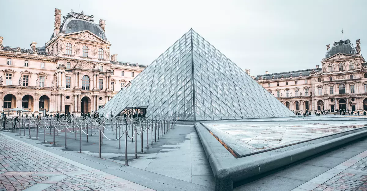 Iconic Louvre Pyramid in Paris, showcasing classic and modern architecture.
