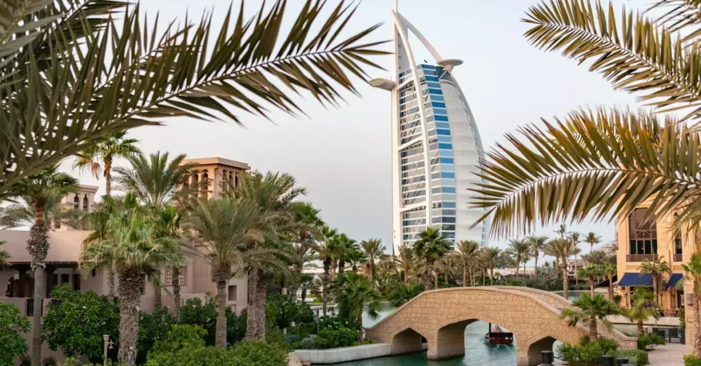 Best Dubai Luxury Experiences: Opulence Awaits 4 Scenic view of Burj Al Arab with surrounding palm trees and bridge in Dubai, UAE.