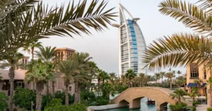 Scenic view of Burj Al Arab with surrounding palm trees and bridge in Dubai, UAE.