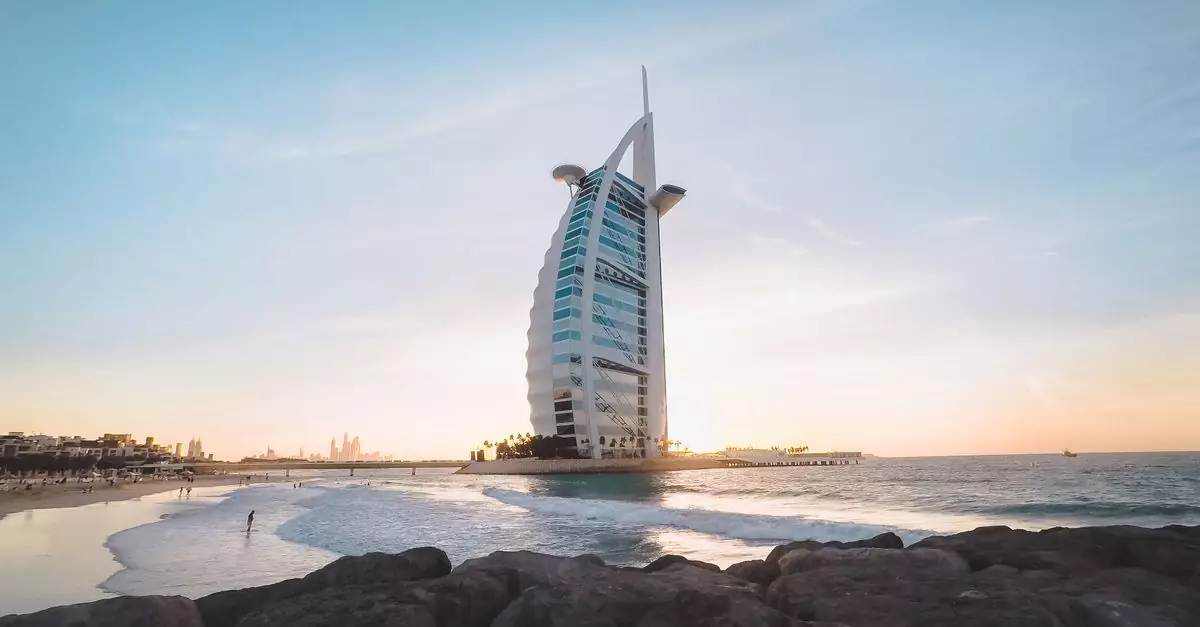 Low angle of Burj Al Arab located on sandy coast of Dubai against cloudless sundown sky