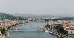 A stunning aerial photograph of Budapest featuring the Chain Bridge spanning the Danube River with cityscape views.