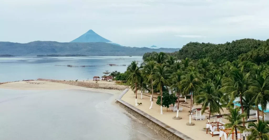 Best Eco Resorts on Island Destinations for Sustainable Travel 2 Aerial view capturing the scenic beauty of Mayon Volcano and the tropical coastline in Legazpi City, Philippines.
