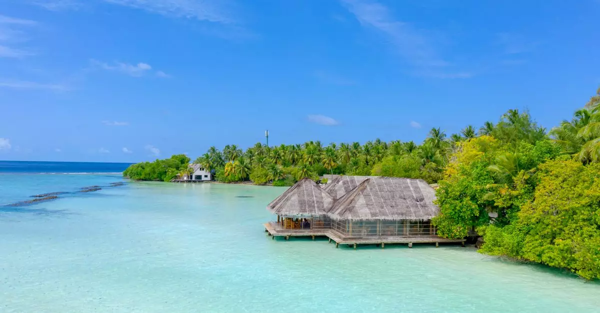A tranquil overwater bungalow surrounded by azure waters and lush greenery in the Maldives.
